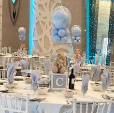 a table set up for a baby's first birthday party with balloons and teddy bears