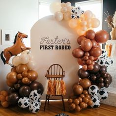 a chair sitting in front of a sign with balloons on it that say foster's first rodeo