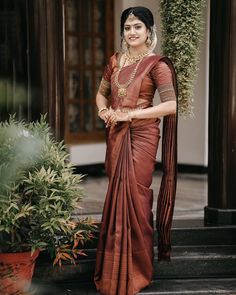 a woman in a brown sari standing on steps