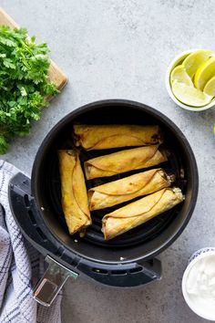 an overhead view of some food in a pot with lemons and cilantro