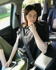 a woman sitting in the back seat of a car