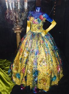 a mannequin dressed in a yellow dress with blue and red flowers on it