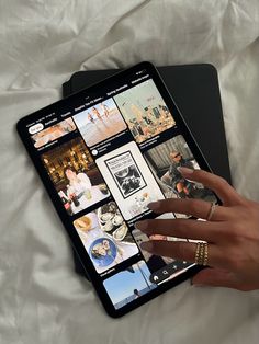 a person's hand is touching the screen of an ipad with pictures on it