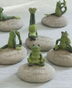 seven frog figurines sitting on rocks with the words create balance written on them