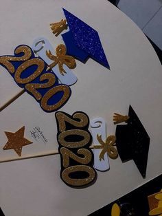 graduation decorations on top of a white table with blue and gold glitters in the shape of numbers