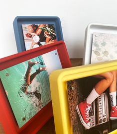 three different colored frames sitting on top of a wooden table