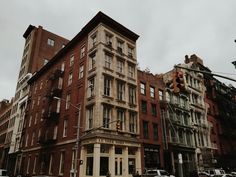 an old brick building in the middle of a city with cars parked on the street