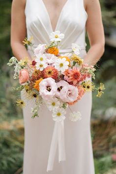 a woman holding a bouquet of flowers in her hands