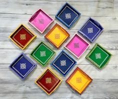 colorful trays with designs on them sitting on a wooden surface, all in different colors