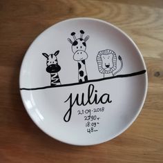 a personalized plate with two giraffes and a zebra on it for a baby's birth