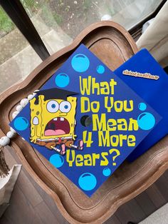 a blue graduation cap that says what do you mean 4 more years?