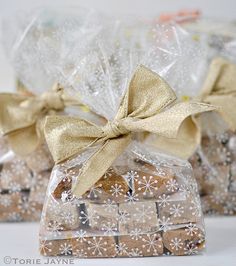 some cookies are wrapped in plastic bags and tied with bows on top of each other