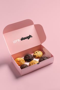 a pink box filled with cookies on top of a table