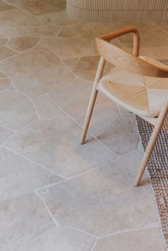 a wooden chair sitting on top of a tiled floor