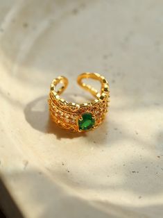 Metal: 18K Recycled Gold Plated On Brass Gemstone: Cubic Zirconia Ring Higt: 13mm Size: Open Adjustable Weight: 6g Gold Diamond Open Ring With Gemstone, Gold Diamond Ring With Gemstone In Open Style, Gold Emerald Ring With Diamond Cut Cubic Zirconia, Luxury Gold Emerald Ring For May Birthstone, Luxury Gold Emerald Open Ring, Gold Emerald Ring With Diamond Cut For May Birthstone, Elegant Gold Plated Rings For May Birthstone, Elegant Gold Plated May Birthstone Ring, Gold Crystal Ring For Formal Occasions In May