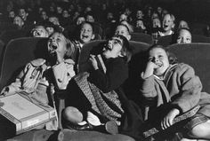 several children sitting in an auditorium with their mouths open