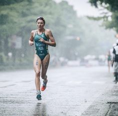 a woman running in the rain wearing a swim suit