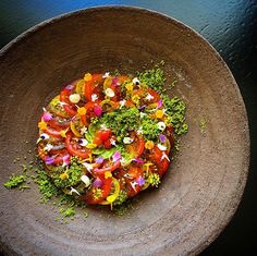 there is a small plate with food on it that includes tomatoes, broccoli and other veggies