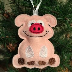 a pink pig ornament hanging from a christmas tree