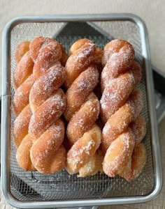 powdered sugar covered donuts sitting in a basket