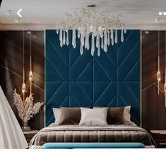 a bedroom with a blue headboard and chandelier hanging from it's ceiling