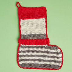 two crocheted oven mitts on a green surface