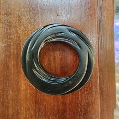 a wooden door with a black metal ring on it's front and side panel