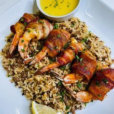 a plate with shrimp, rice and dipping sauce