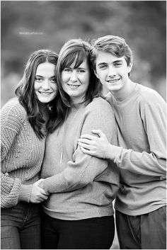 black and white photograph of three people hugging each other