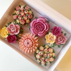 an open box filled with fake flowers on top of a table