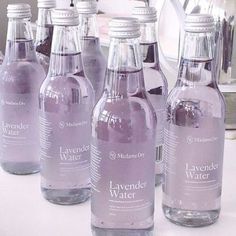 six bottles of lavender water are lined up on a counter