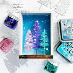 an assortment of crafting supplies on a white table with snowflakes and christmas trees