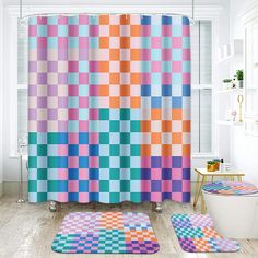 a colorful shower curtain and rugs in a bathroom