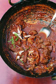 a pot filled with meat and vegetables on top of a table