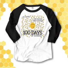 a white and black shirt with the words 100 days of school written on it in front of honeycombs