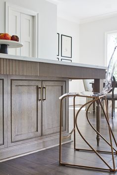 a modern kitchen with an island and bar stools in the center, surrounded by wood flooring