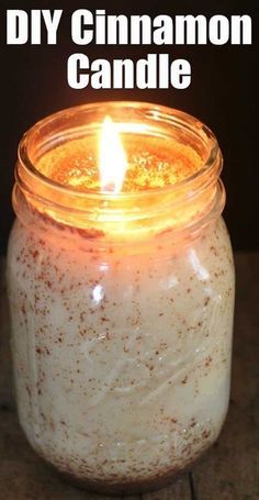 a candle that is sitting in a jar on a table with the words diy cinnamon candle