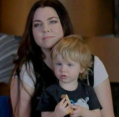 a woman sitting next to a little boy