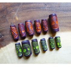 there are many different types of nail polishes on the wooden table, including one with green and orange designs