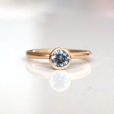 a gold ring with a blue diamond on it