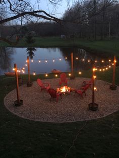 a fire pit with chairs and lights around it