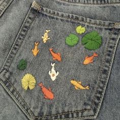 a pair of jeans with fish and lily pads on them