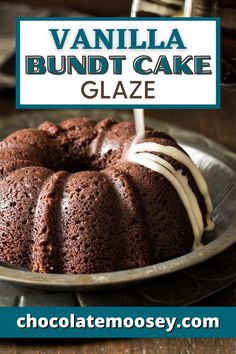 a chocolate bundt cake with white icing on a silver plate and the words vanilla bundt cake glaze above it