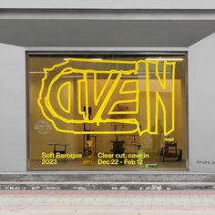 a store front with neon yellow lettering on the window