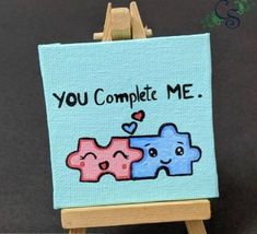 an easel with a painting on it that says you complete me