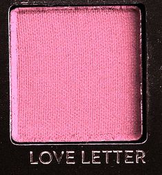 a close up of a pink eye shadow on a black background with the words love letter