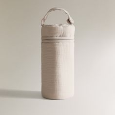 a white bag sitting on top of a table next to a wall with an object hanging from it