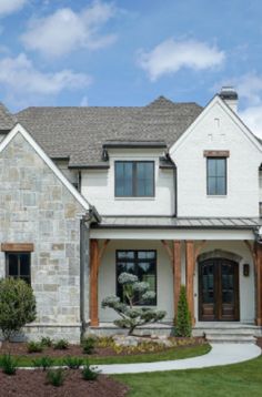 a large white house with stone and wood accents