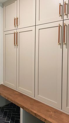 a kitchen with white cabinets and wood counter tops