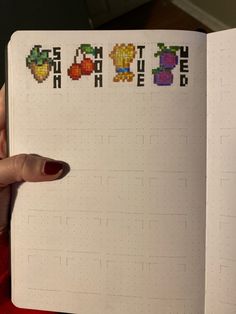 a hand holding an open notebook with the word game on it and four pixel characters